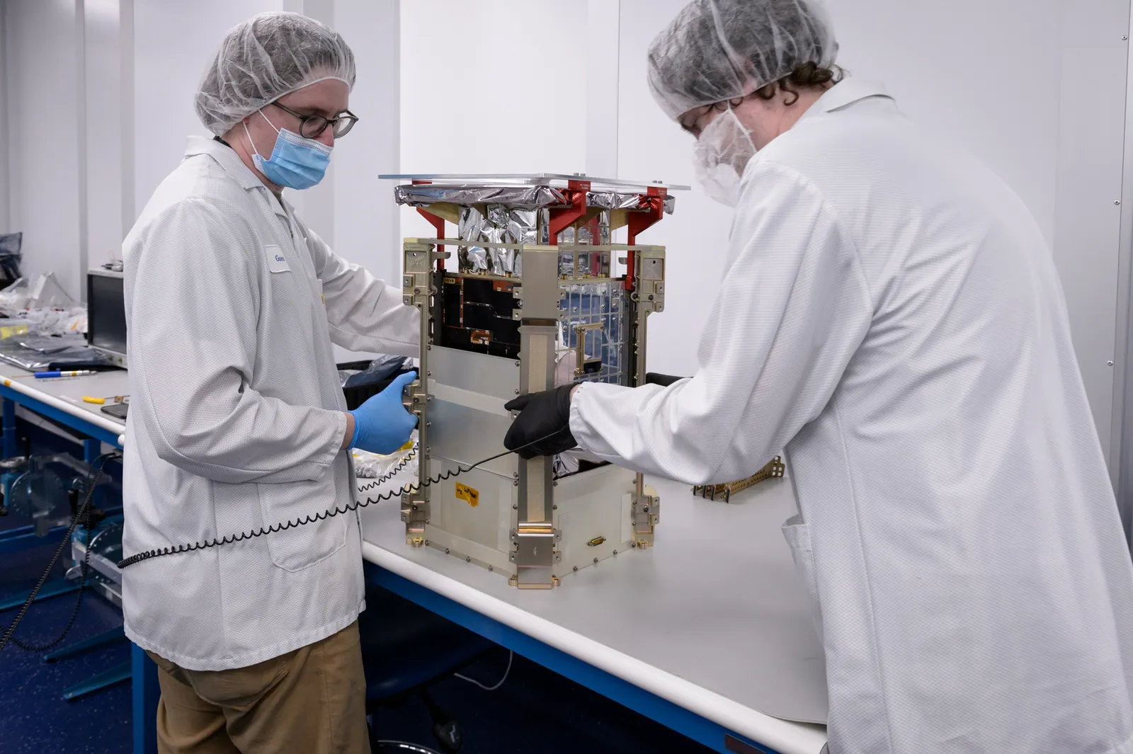 兩名工程師與收進分離器的 CAPSTONE 立方衛星